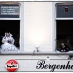 People at windows above a Jupiler sign.