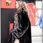 Woman in black coat with red umbrella