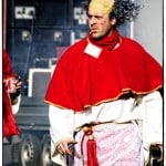Person in costume with wig and cigarette on street.