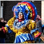 Colorful performer in elaborate costume on street.