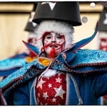 Carnival performer in colorful, starry costume and makeup.